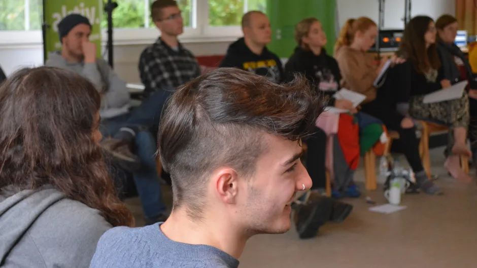 Junge Menschen auf Stühlen diskutieren